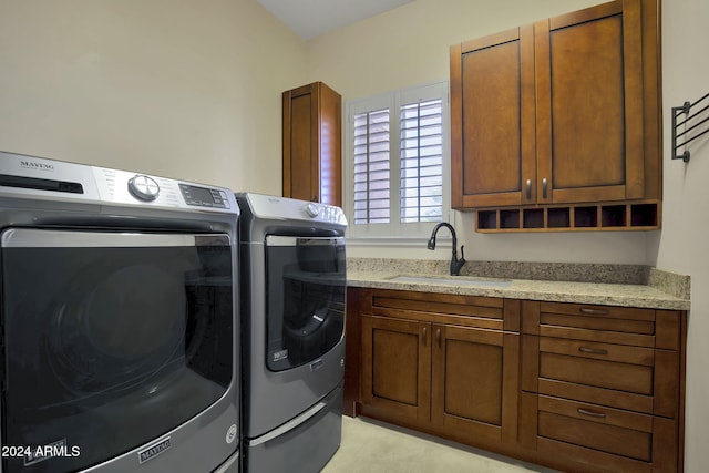 laundry area with cabinets, washing machine and dryer, and sink