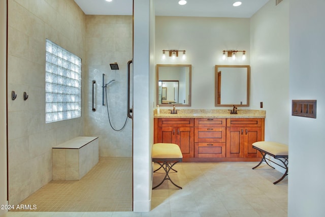 bathroom with a tile shower, tile patterned floors, and vanity