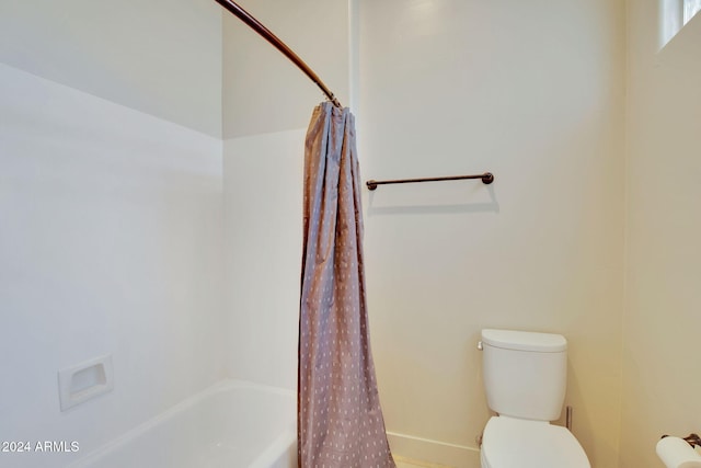 bathroom with shower / bath combination with curtain and toilet