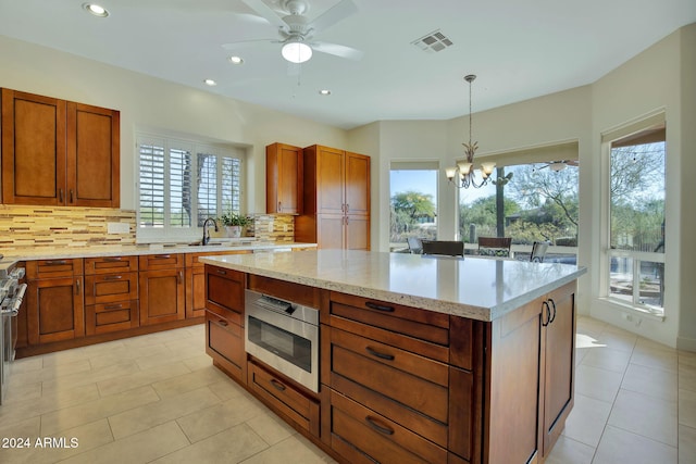 kitchen with backsplash, decorative light fixtures, a center island, and stainless steel appliances