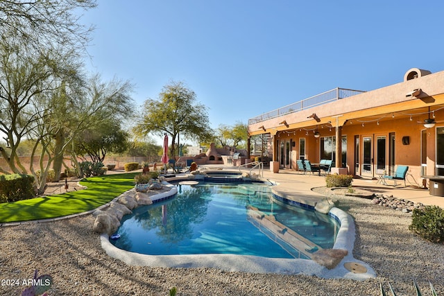 view of swimming pool with a patio area and an in ground hot tub