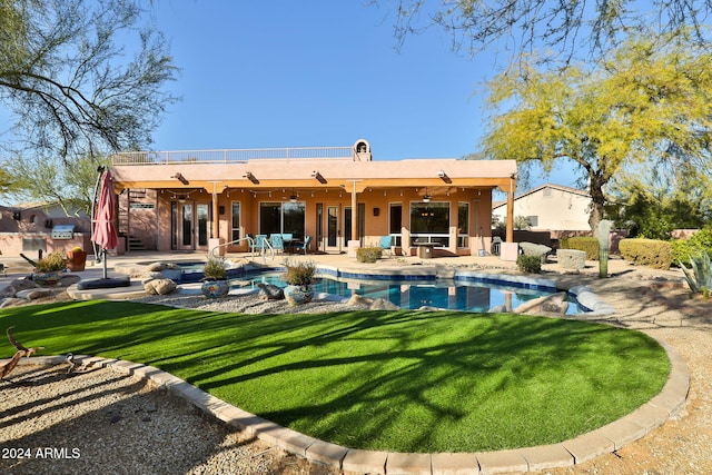 rear view of property featuring a lawn, outdoor lounge area, ceiling fan, and a patio