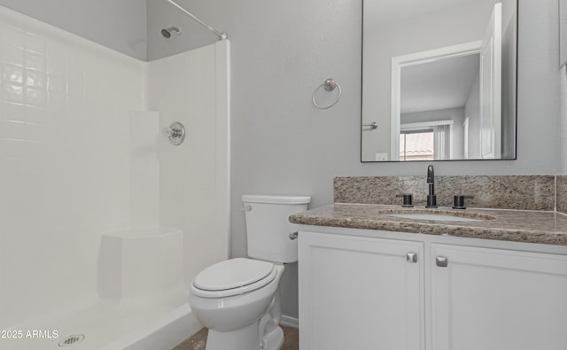 bathroom featuring vanity, toilet, and walk in shower