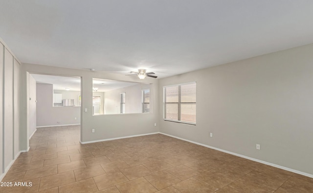 empty room featuring light tile patterned flooring and ceiling fan