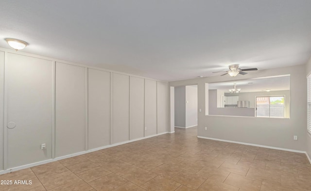 spare room with ceiling fan with notable chandelier