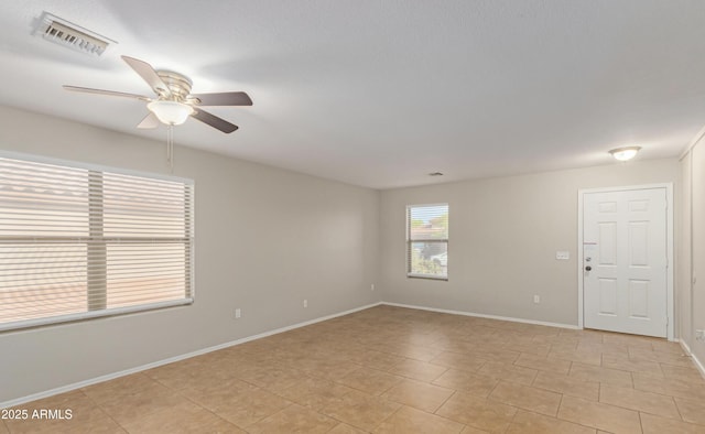 tiled empty room featuring ceiling fan