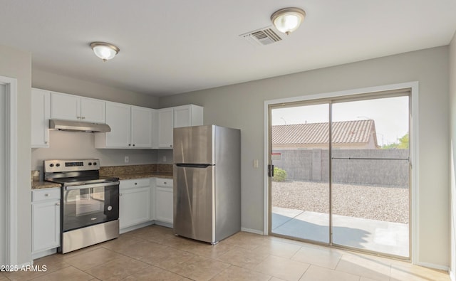 kitchen with stainless steel appliances, light tile patterned flooring, and white cabinets