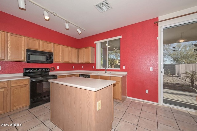 kitchen featuring light tile patterned floors, a kitchen island, sink, and black appliances