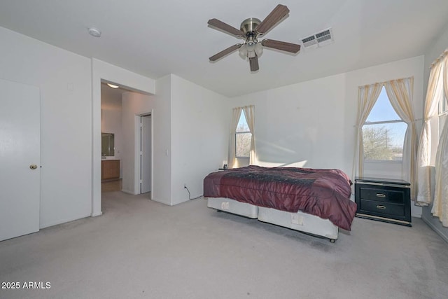 bedroom featuring connected bathroom, ceiling fan, and light colored carpet