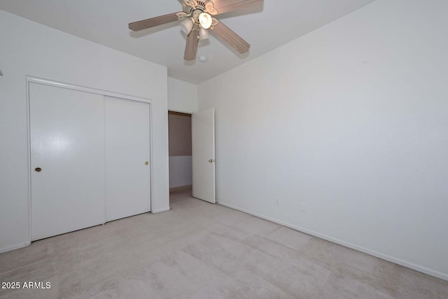 unfurnished bedroom featuring ceiling fan, light colored carpet, and a closet