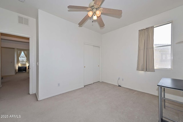 unfurnished bedroom with ceiling fan, a closet, and light colored carpet