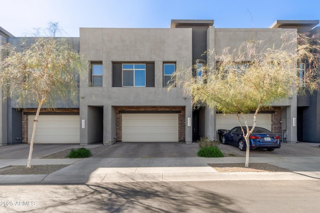 view of front of home featuring a garage, driveway, and stucco siding