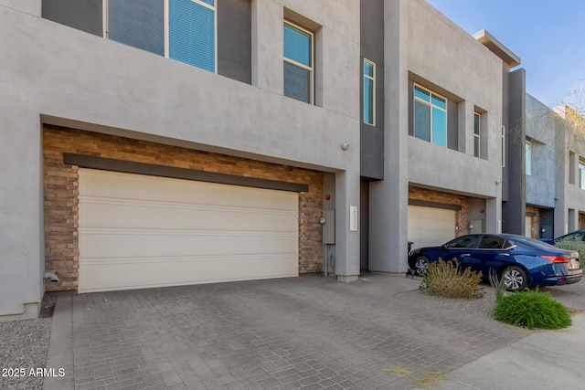 view of front facade with a garage and stucco siding