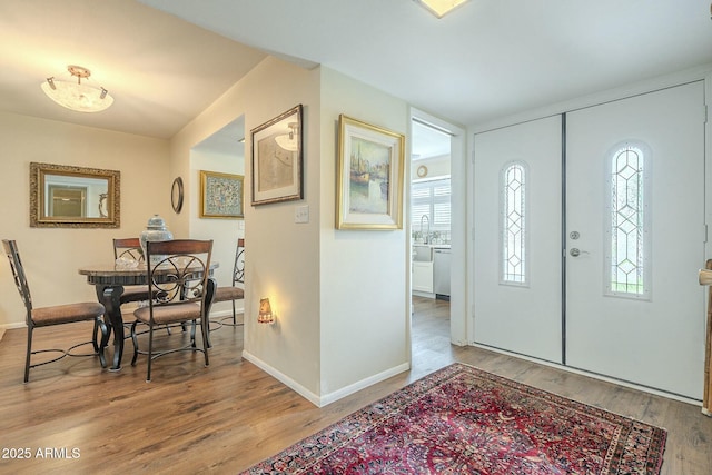 entrance foyer with baseboards and wood finished floors