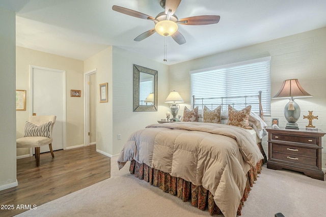 bedroom featuring a ceiling fan, carpet, baseboards, and wood finished floors