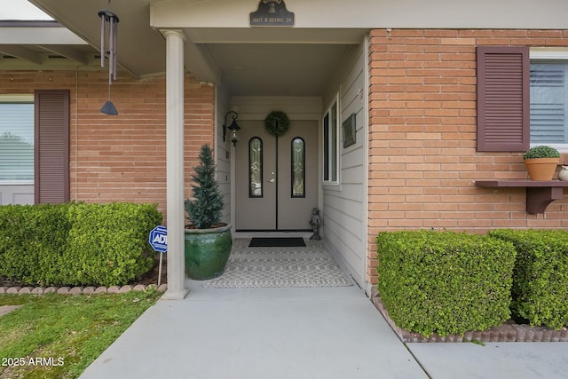 doorway to property featuring brick siding