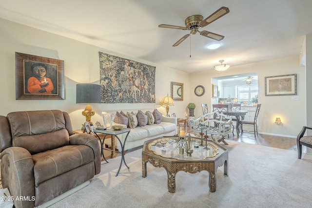 living room with carpet flooring, baseboards, and ceiling fan