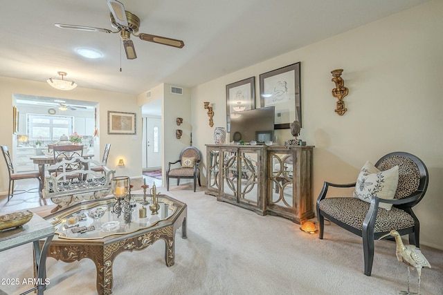 living area featuring a ceiling fan, carpet, and visible vents