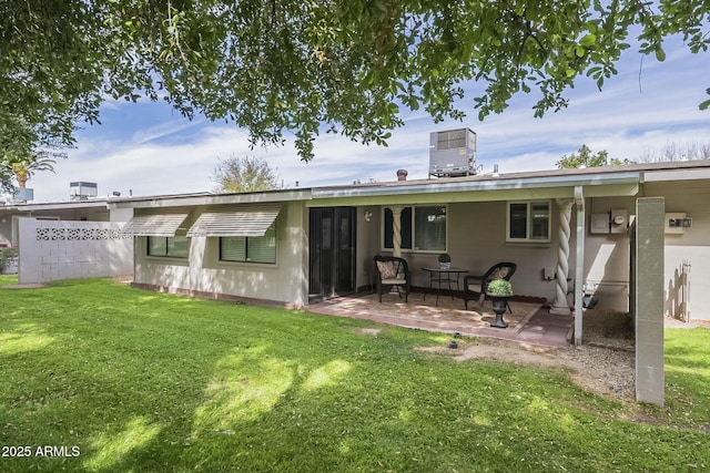 back of property with a yard, a patio area, and cooling unit