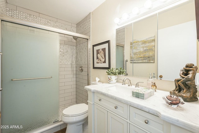 bathroom with a stall shower, toilet, and vanity