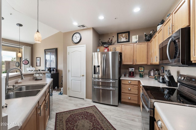 kitchen featuring hanging light fixtures, sink, stainless steel appliances, and light hardwood / wood-style floors