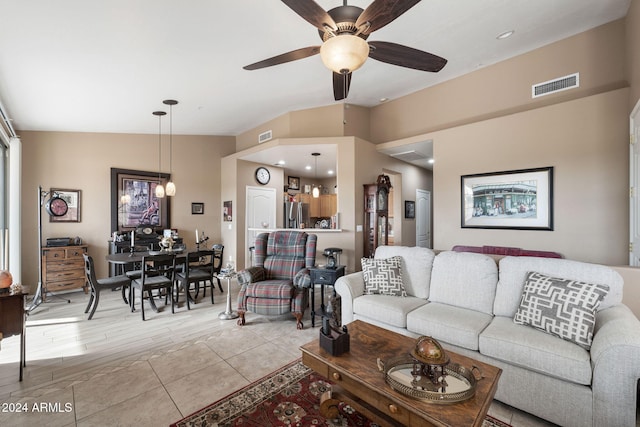 living room with ceiling fan, vaulted ceiling, and light wood-type flooring