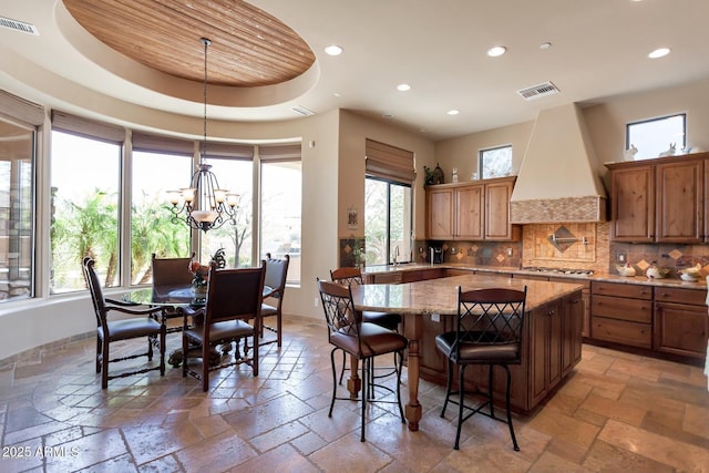 35195 N 98th St Unit 85, Scottsdale, AZ 85262 - kitchen with stone tile flooring, recessed lighting, custom exhaust hood, a kitchen island, and backsplash