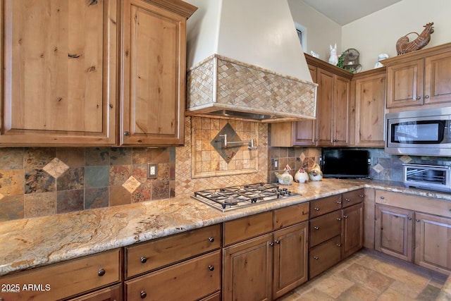 35195 N 98th St Unit 85, Scottsdale, AZ 85262 - kitchen with stainless steel appliances, wall chimney range hood, light stone countertops, tasteful backsplash, and stone finish floors