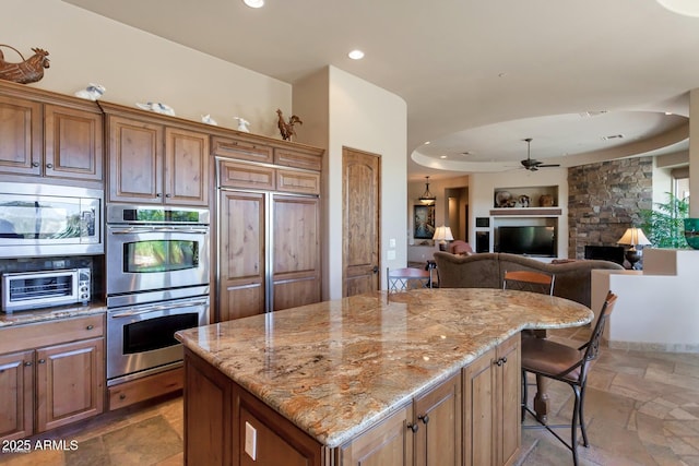 35195 N 98th St Unit 85, Scottsdale, AZ 85262 - kitchen with appliances with stainless steel finishes, stone tile flooring, built in features, a ceiling fan, and light stone counters