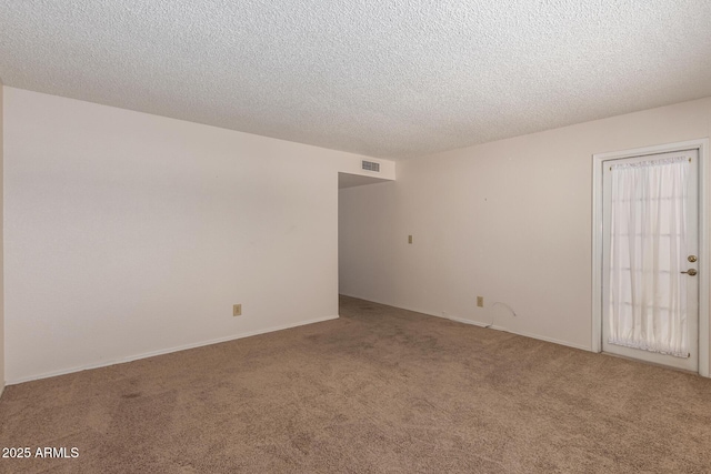 empty room with visible vents, carpet flooring, and a textured ceiling