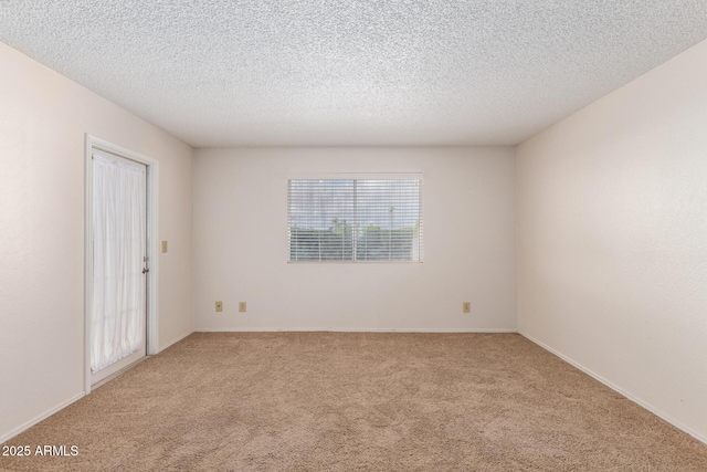 empty room with light carpet and a textured ceiling