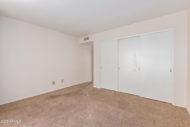 unfurnished bedroom featuring a closet, visible vents, and carpet floors