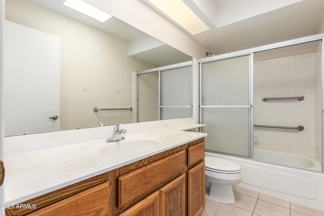 full bath featuring vanity, tile patterned floors, toilet, and combined bath / shower with glass door