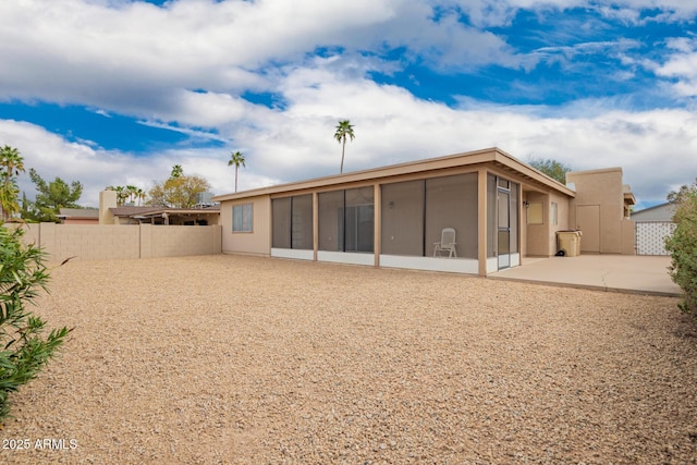 rear view of house with a patio, a fenced backyard, and a sunroom