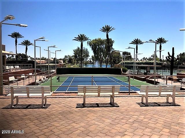 view of pool featuring a tennis court and fence