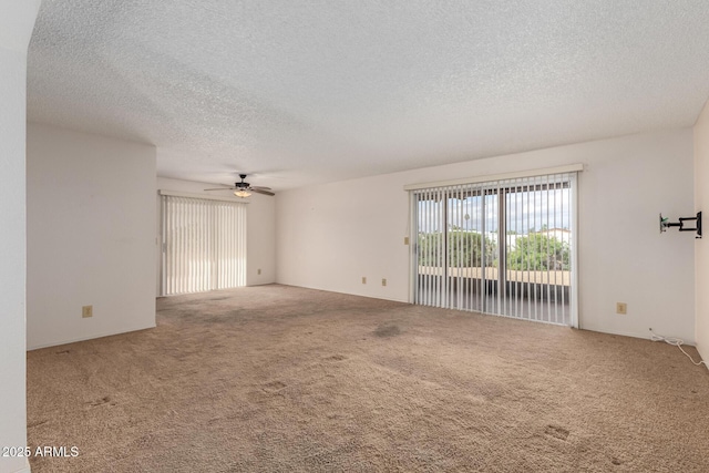 spare room with carpet flooring, a textured ceiling, and a ceiling fan