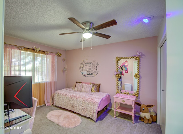 carpeted bedroom with a closet, a textured ceiling, and ceiling fan