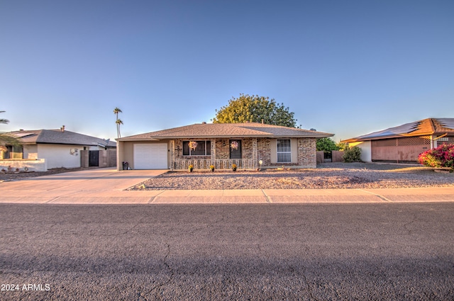 single story home featuring covered porch and a garage