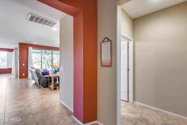 hallway with plenty of natural light and light tile patterned floors