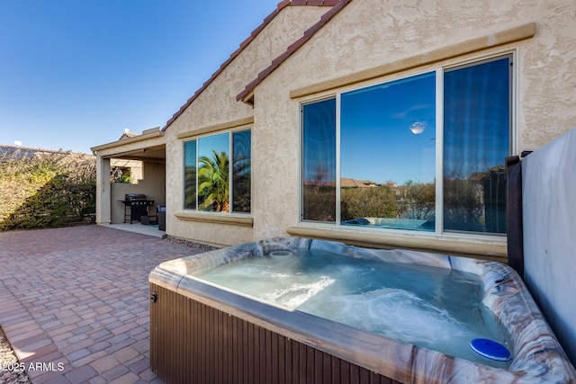 view of patio / terrace with grilling area and a hot tub