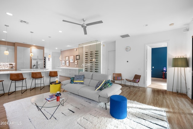 living room featuring light hardwood / wood-style flooring and ceiling fan