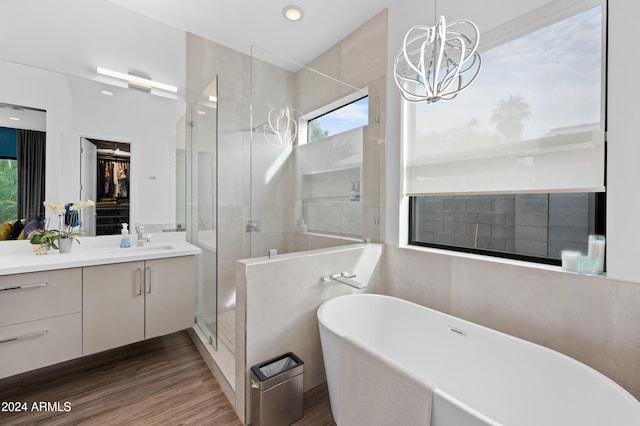 bathroom featuring vanity, hardwood / wood-style flooring, an inviting chandelier, and independent shower and bath