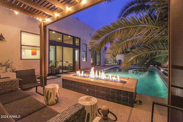 view of pool with a pergola, a patio, and an outdoor living space with a fire pit