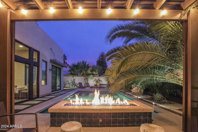 pool at twilight with an outdoor fire pit