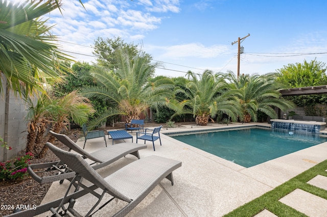 view of swimming pool with pool water feature, a hot tub, and a patio area