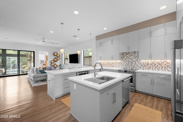 kitchen featuring pendant lighting, a kitchen island with sink, sink, ceiling fan, and stainless steel appliances