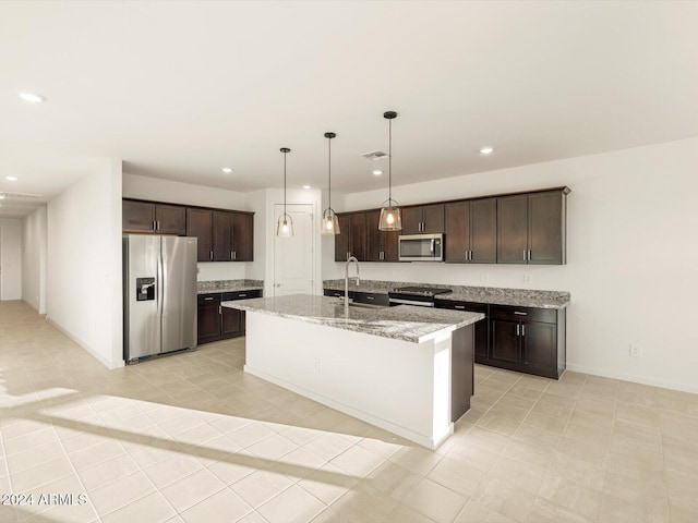 kitchen featuring sink, hanging light fixtures, dark brown cabinets, stainless steel appliances, and an island with sink