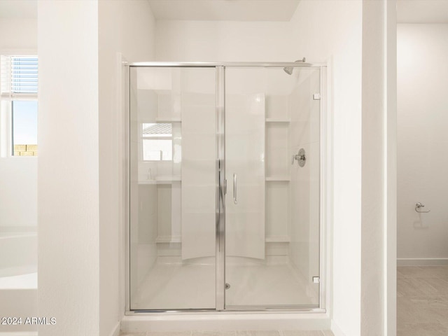 bathroom with an enclosed shower and a healthy amount of sunlight