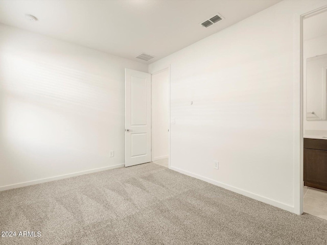 spare room featuring light colored carpet