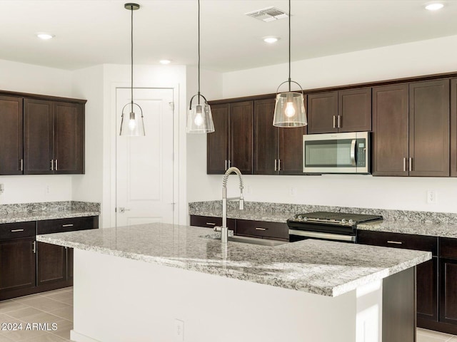 kitchen with appliances with stainless steel finishes, sink, a center island with sink, and dark brown cabinetry